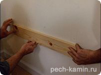 Закрепите две доски к стене гвоздиками