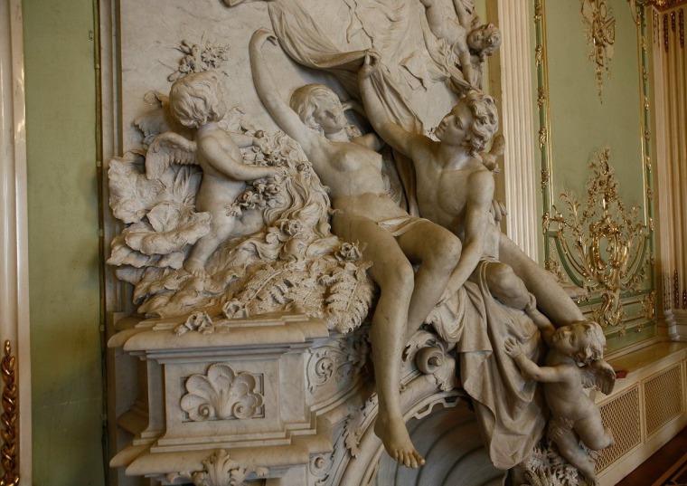 Однотонный камин барокко с объёмным декором